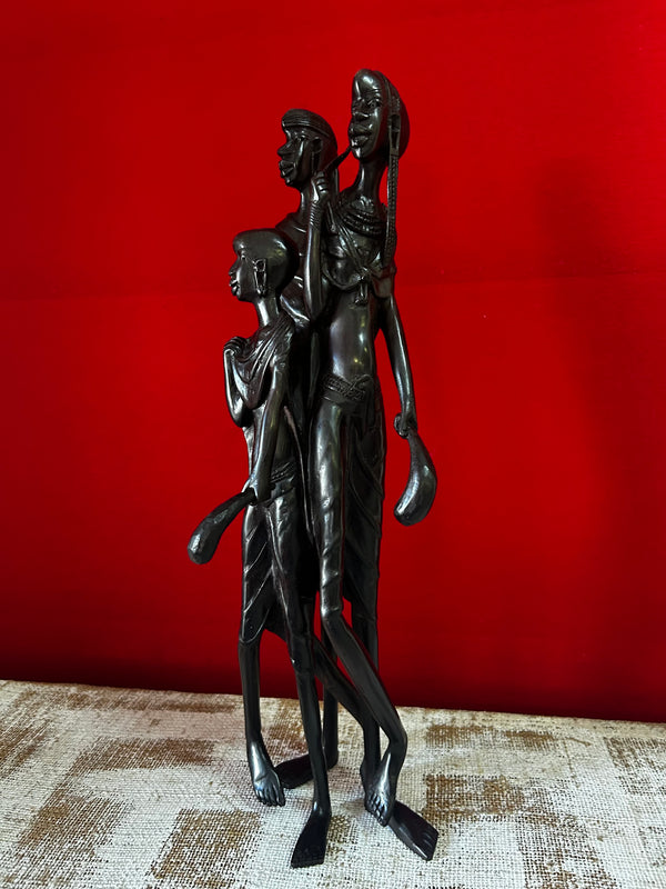 Ebony wood sculpture of a Maasai family, handcrafted in Tanzania, displayed in Rogl Souvenirs & Gallery, African art gallery.