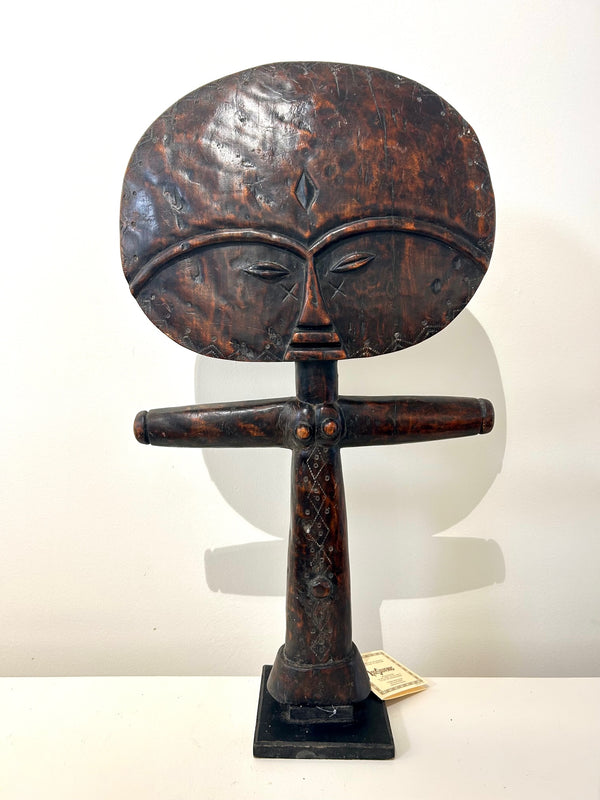 Akuaba fertility doll sculpture from the Ashanti tribe in Ghana, featuring a rich patina and maroon color, symbolizing beauty and motherhood.