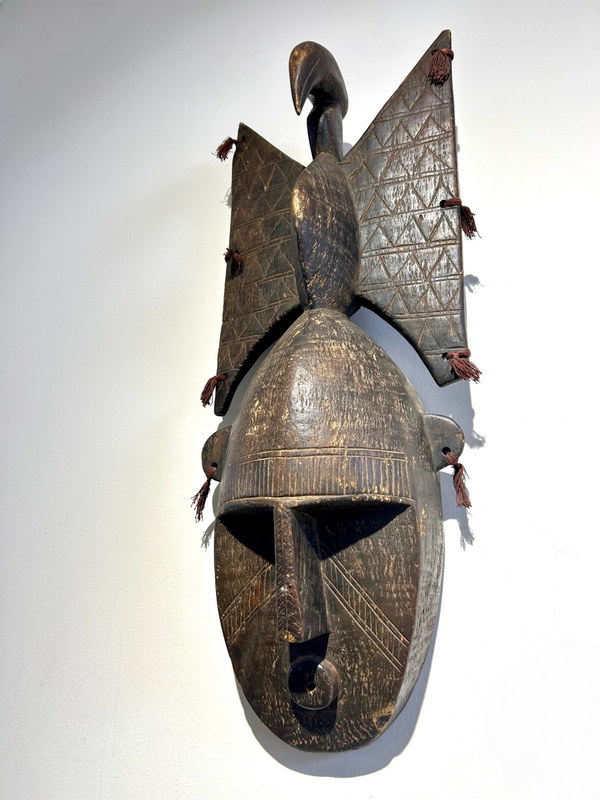 Bambara tribe mask from Mali with bird headgear, intricate carvings, and rich patina, displayed at Rogl Souvenirs & Gallery.