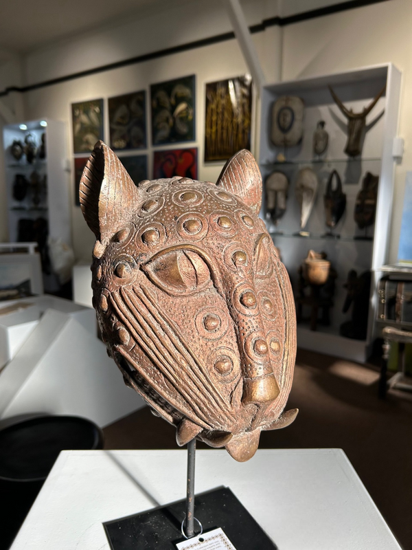 Bronze leopard head sculpture handcrafted by Ife artisans from Benin, symbolizing patience and power, displayed in Rogl Souvenirs & Gallery.