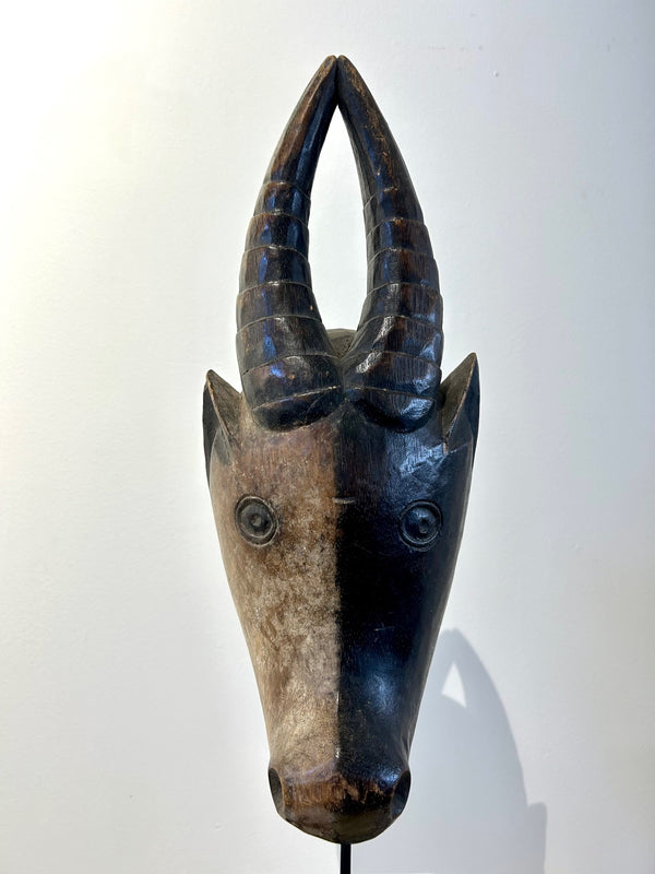 Hausa antelope mask from Cameroon with black and white contrasting colors symbolizing duality and balance.