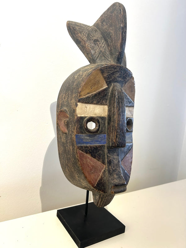 Bamum ancestral mask from Cameroon with colorful geometric patterns, symbolizing cultural identity and history, displayed at Rogl Souvenirs & Gallery.