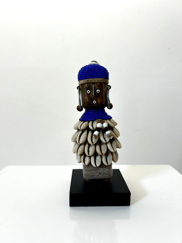 Beaded Namji doll from Cameroon, adorned with indigo beads and cowrie shells, representing fertility and motherhood.