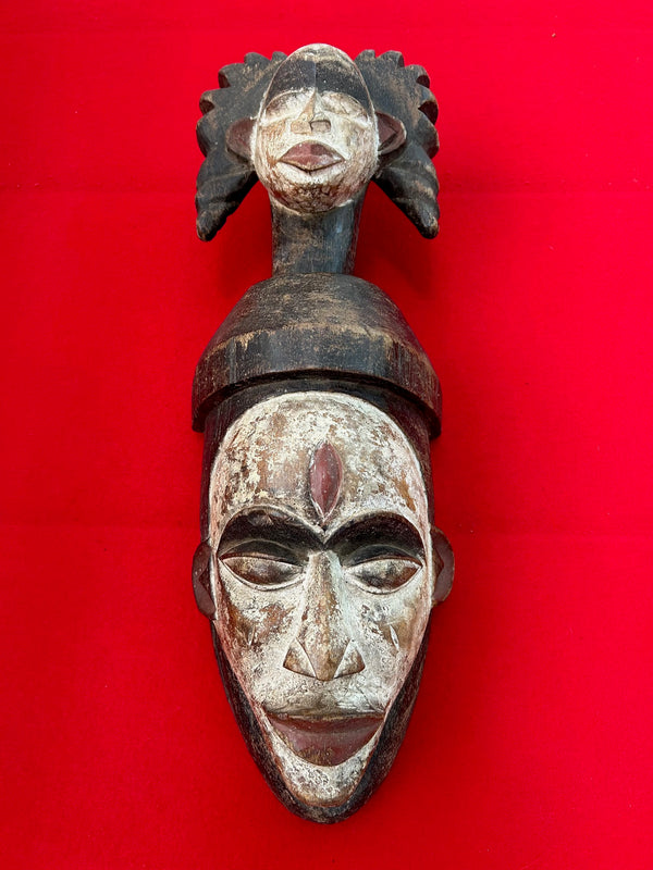 Double-headed Fang mask from Cameroon, used in traditional dances to connect with ancestors, featuring intricate patterns and vibrant colors.