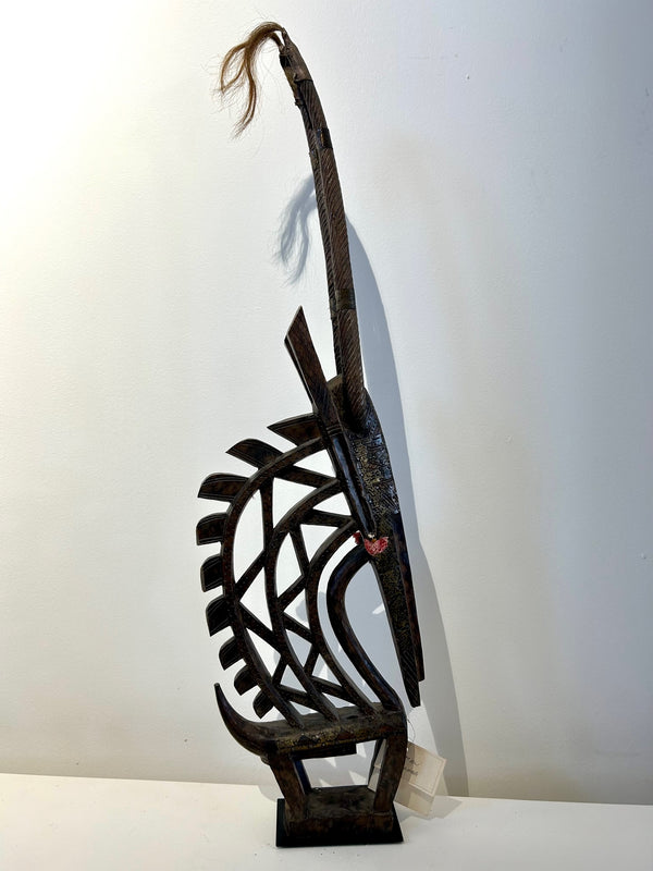 Chiwara mask from the Bambara tribe in Mali, male version with a mane, representing an antelope, used in traditional dances for prosperity and good harvests, displayed in Rogl Souvenirs & Gallery.