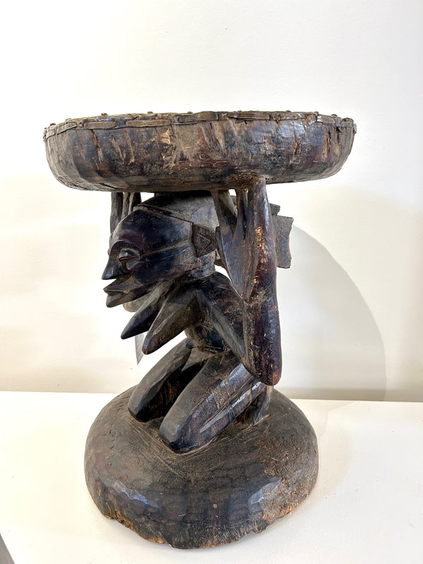 Brass-covered wood chair from the Chokwe tribe in Congo-Zaire, symbolizing royalty and authority, with intricate engravings and cultural significance.