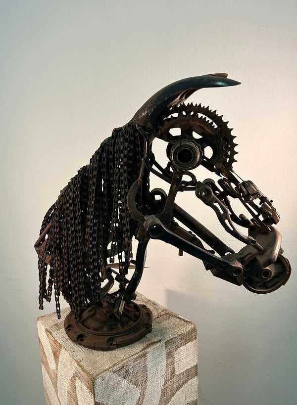 Sculpture of a horse head made from wrenches and bicycle chains, showcasing industrial art at Rogl Souvenirs & Gallery, Namibia.