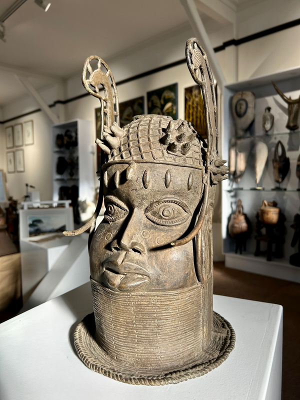 Bronze head sculpture of an Ife Oba from the Kingdom of Benin, showcasing intricate craftsmanship and traditional royal helmet, displayed in Rogl Souvenirs & Gallery.