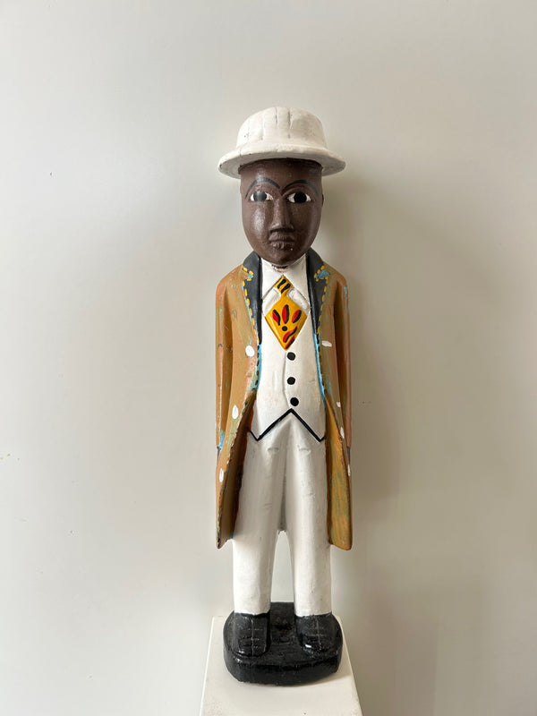 Wooden colonial figure sculpture from Ivory Coast depicting a historical colonial-era businessman, hand-carved and painted in multi-color, displayed at Rogl Souvenirs & Gallery.