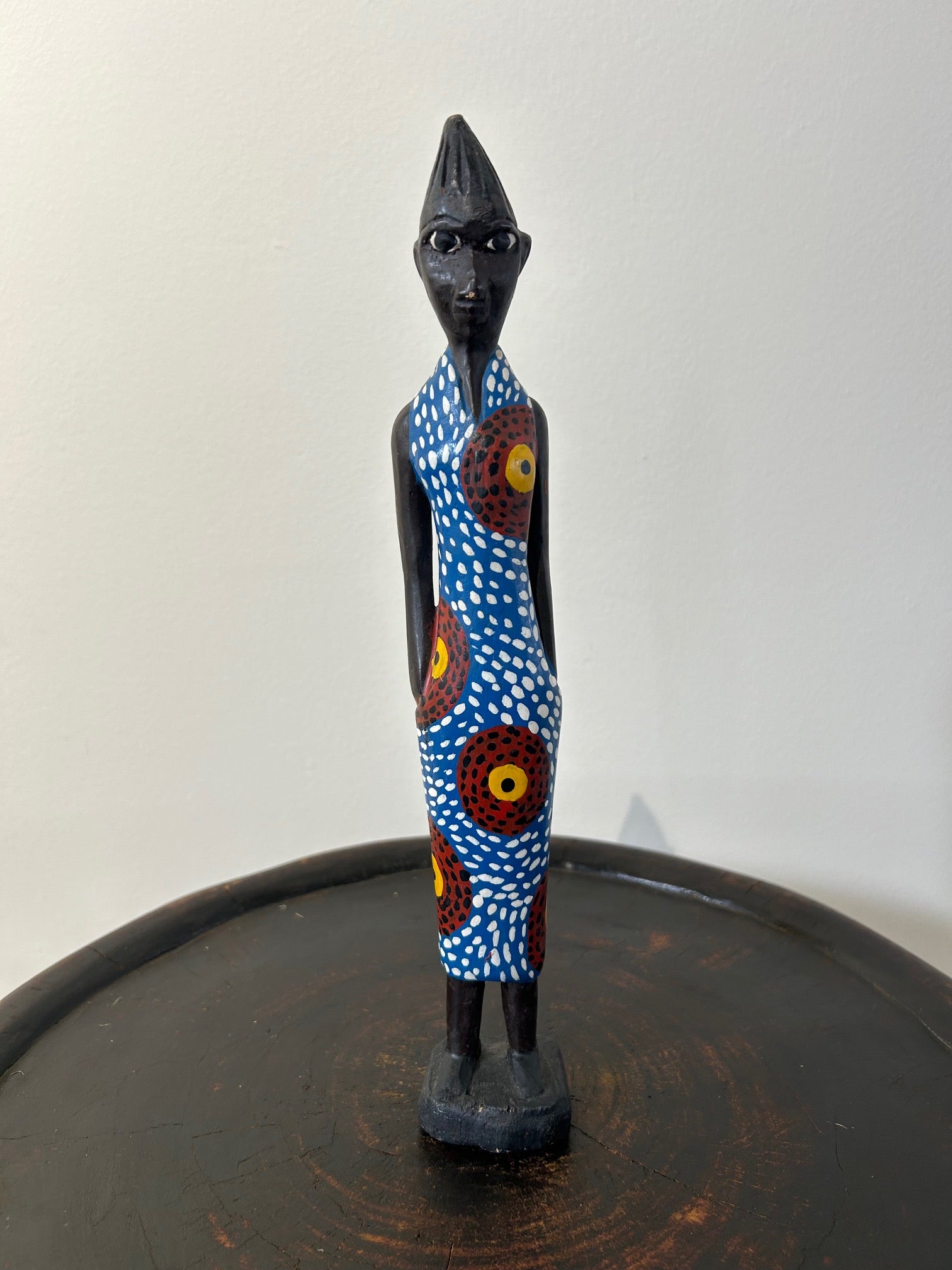 Wooden colonial figure sculpture from Ivory Coast, hand-carved, depicting a modern lady in colorful attire, symbolizing historical colonial influences.