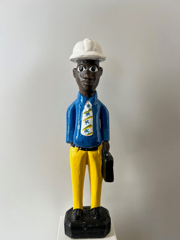 Wooden colonial figure sculpture from Ivory Coast depicting a technician in blue shirt, yellow pants, and white hat, hand-carved with unique multi-color design, available at Rogl Souvenirs & Gallery.
