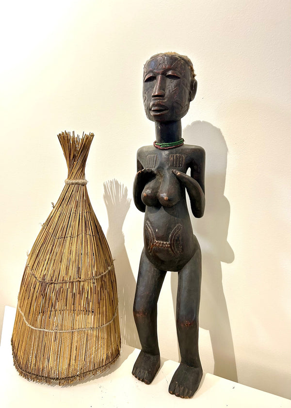 Konde-Makonde ancestor figure sculpture from Tanzania, symbolizing fertility and protection, intricately carved from dark brown wood, displayed in Rogl Souvenirs & Gallery.