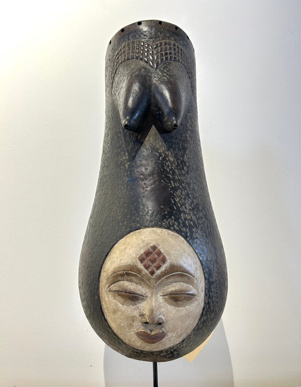 Female body mask from the Konde-Makonde tribe in Tanzania, used in fertility rituals, featuring carved breasts and intricate patterns, displayed at Rogl Souvenirs & Gallery.