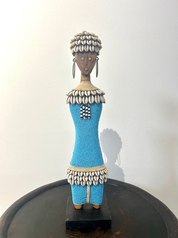 Turquoise Namji doll sculpture adorned with beads and cowrie shells, representing fertility and motherhood, from the Namji tribe in Cameroon.
