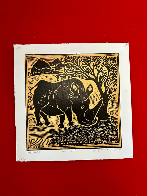 Linocut print of a rhino in black and yellow, showcasing intricate details and textures, created by artist Kapanda, displayed on a red background, African art gallery.