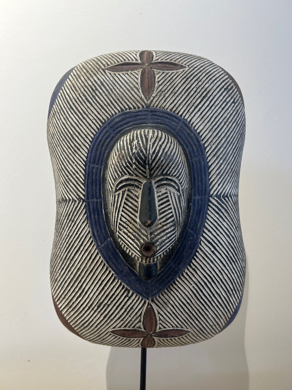 Shield mask from the Songye-Basonge tribe in Congo-Zaire, used for protection and ancestor admiration, featuring intricate traditional artistry and multi-color design.