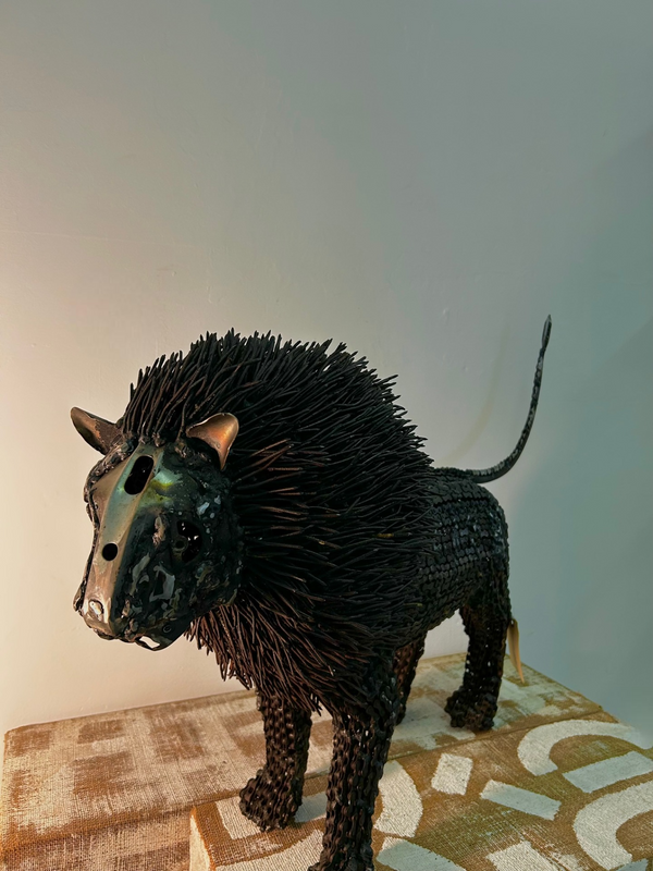 Majestic lion sculpture made from upcycled metal materials, featuring intricate details and a rustic appeal, handcrafted by artisans in Namibia.
